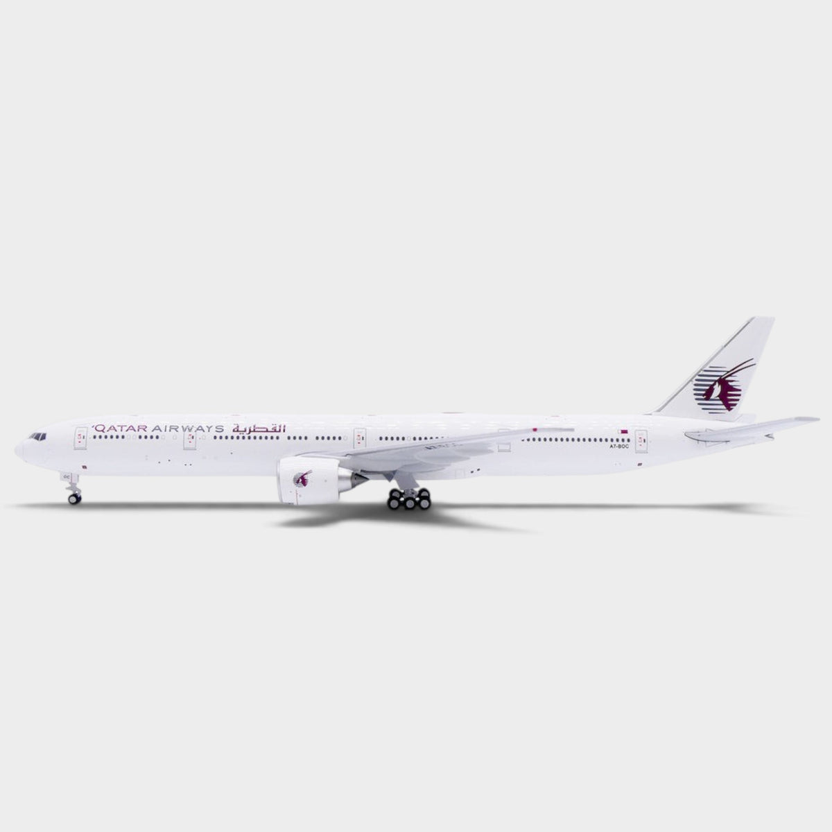 Slice 1:400 scale diecast model of a Qatar Airways Boeing 777-300ER in an all-white livery with landing gear.